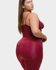 Woman wearing a maroon bodysuit against a white background