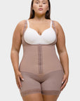 Woman wearing a beige shapewear garment over a white bra on a white background
