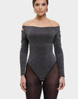 Woman wearing a gray off-shoulder bodysuit on a white background