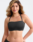 Woman wearing a black sports bra on a plain background