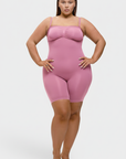 Woman wearing a pink bodysuit against a white background