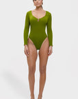 Woman wearing a green swimsuit with long sleeves on a white background