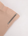 Close-up of beige shorts with a zipper on a light gray background