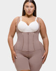 Woman wearing a beige waist trainer over a white top on a plain background