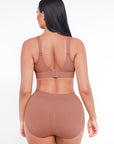 Woman wearing a brown sports bra and high-waisted leggings on a white background