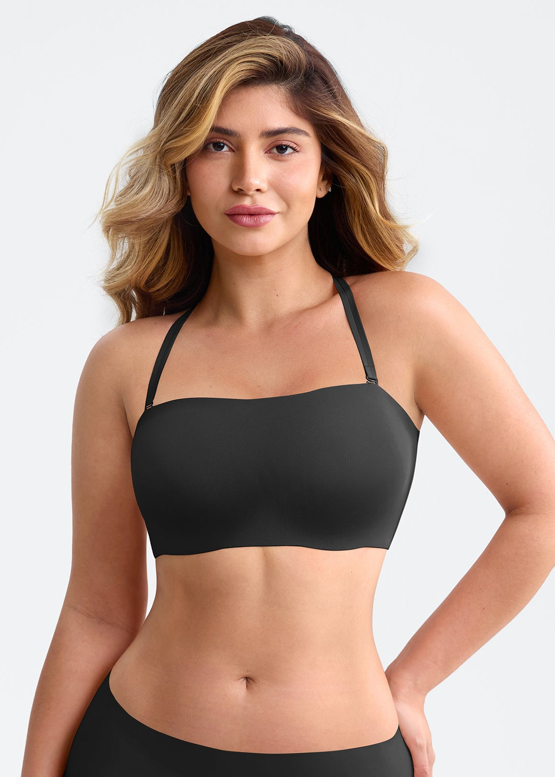 Woman wearing a black sports bra on a plain background
