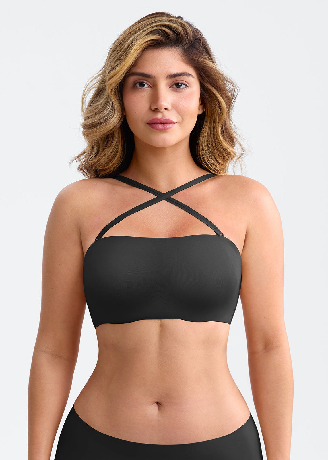 Woman wearing a black strappy top against a white background