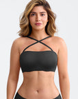 Woman wearing a black strappy top against a white background