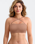 Woman wearing a beige strapless top against a plain background
