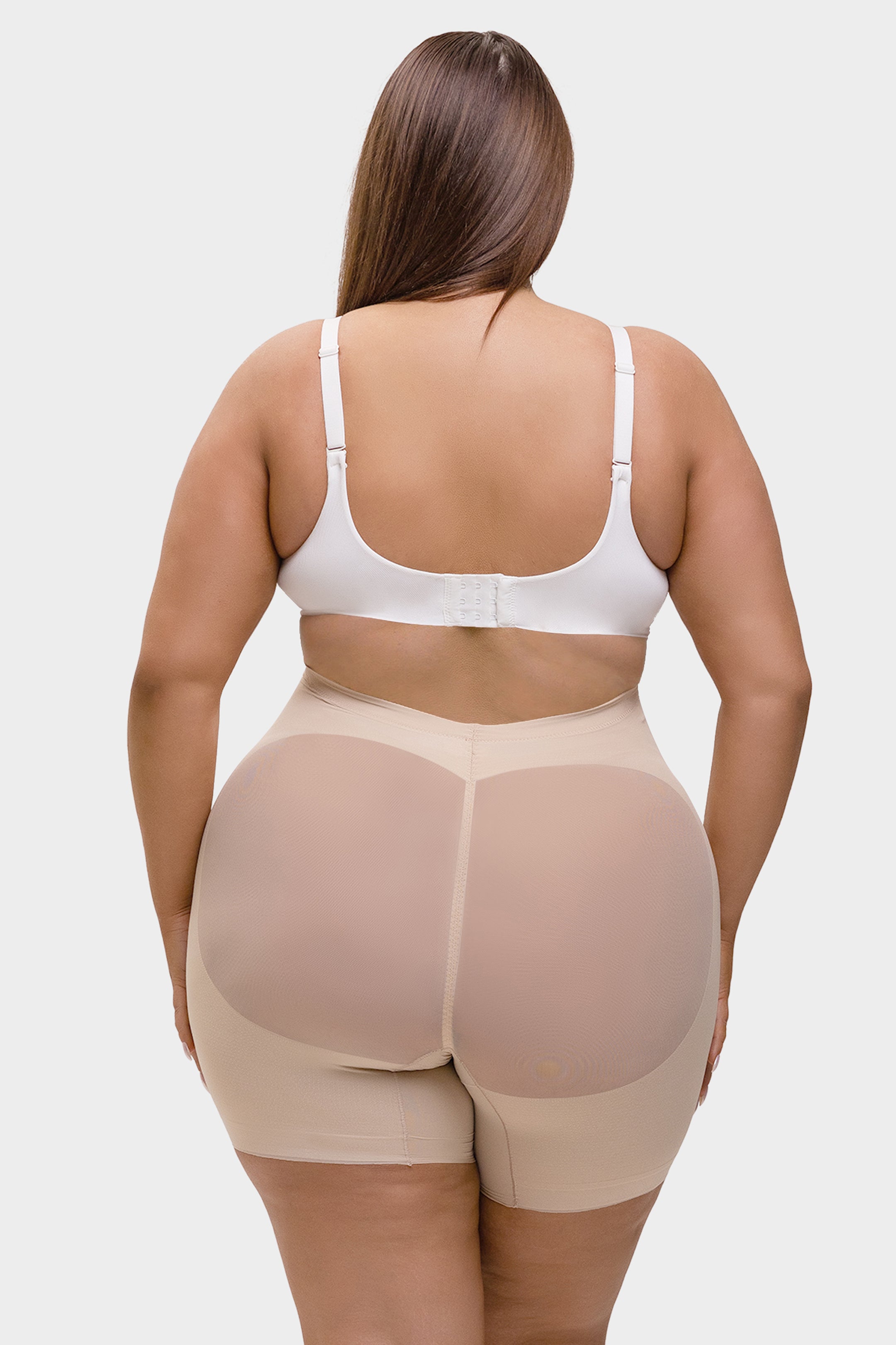 Person wearing a beige shapewear garment on a white background